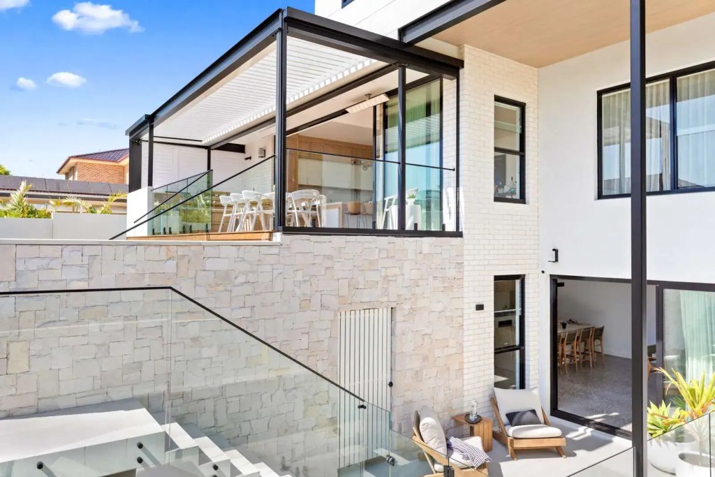 Frenchs Forest home with frameless glass balcony balustrades installed across split levels, featuring matte black interlinking top rail.
