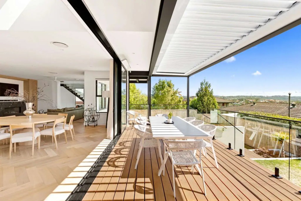 Frenchs Forest home with a frameless glass balcony balustrade featuring matte black deck‑mount spigots and an interlinking top rail.