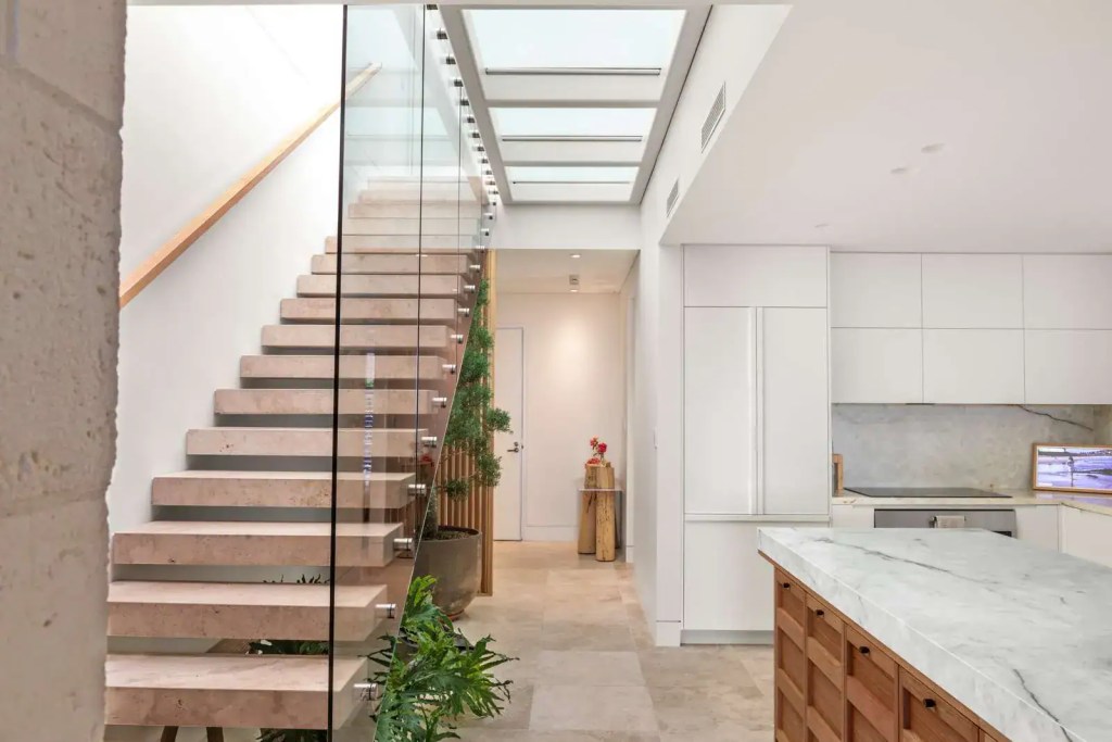 Full height glass balustrade featuring polished stainless-steel standoff brackets installed in a Manly home.