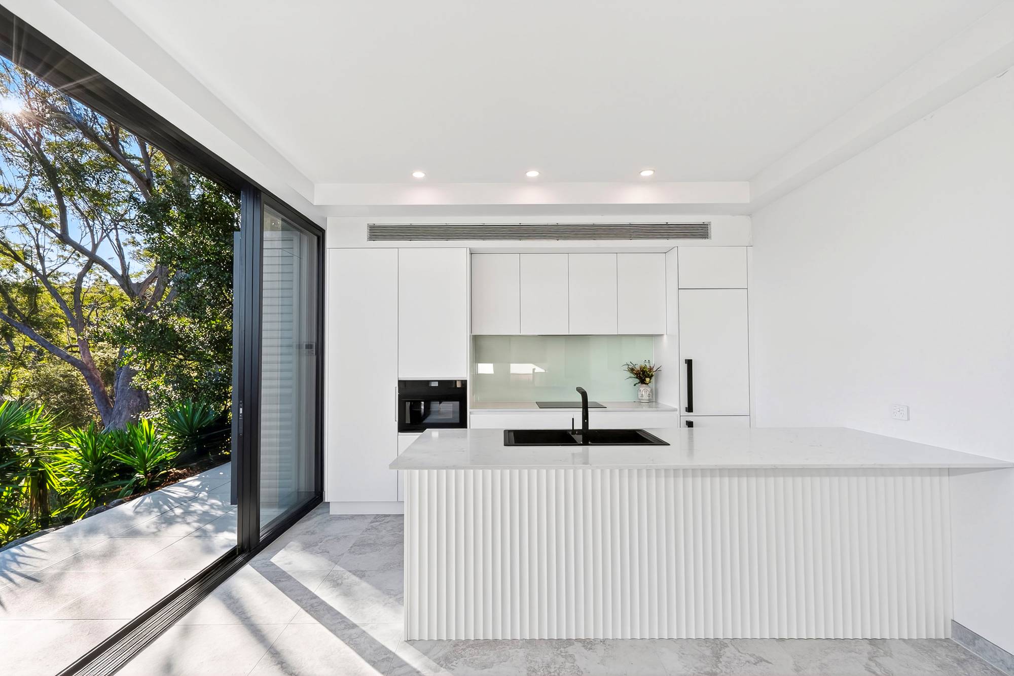 White glass kitchen splashback by First Class Glass, installed in a Northern Beaches home.