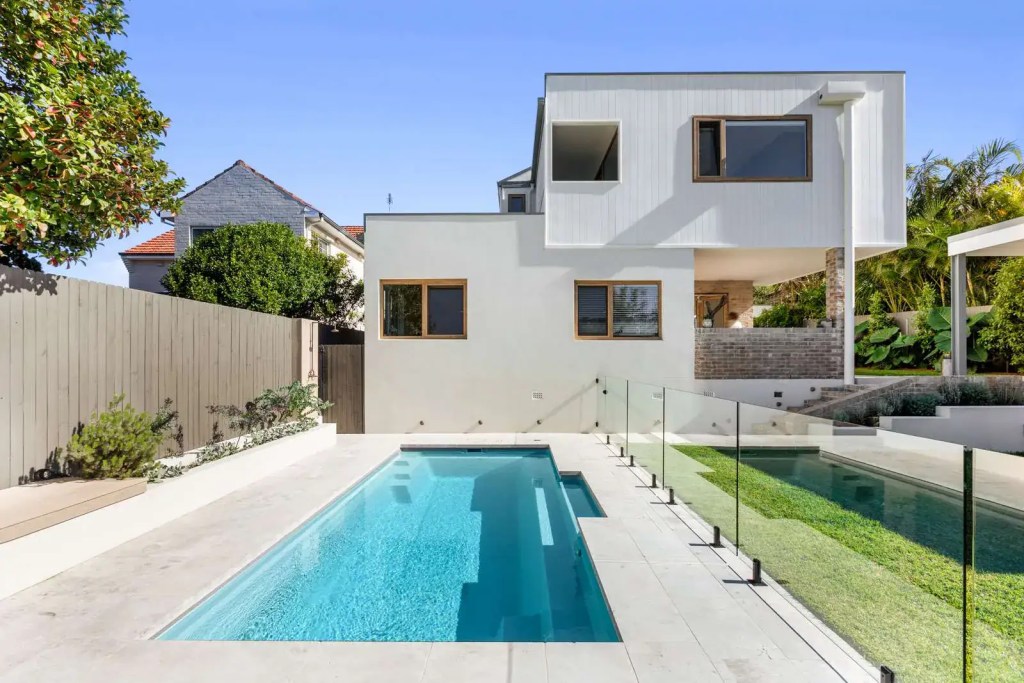 Surface-mounted frameless glass pool fence with matte black hardware finish, installed in a Balgowlah heights home.